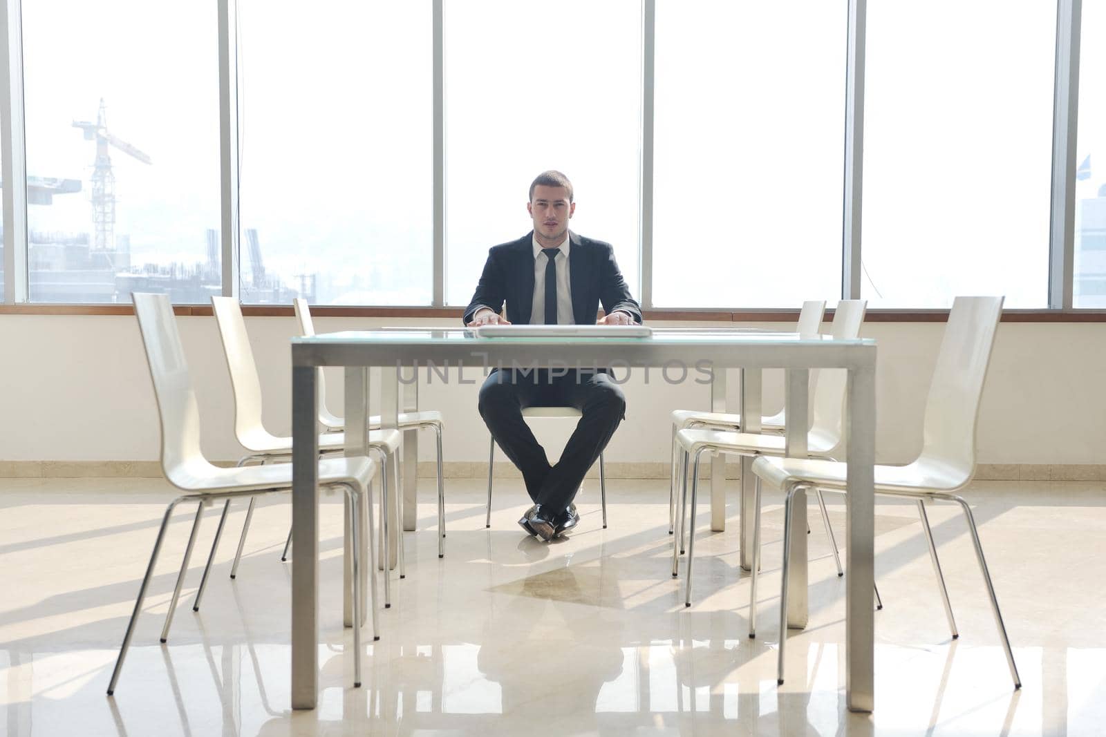 young business man lawyer with laptop alone in big bright   conference room