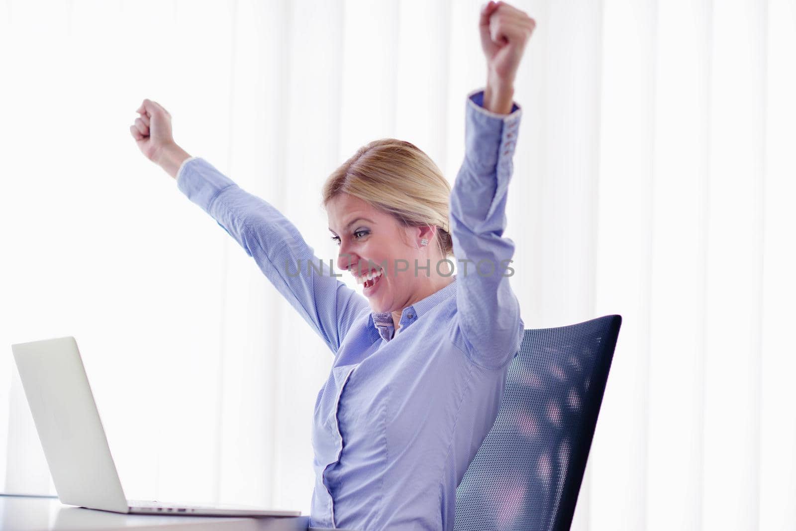 portrait of Young pretty business woman work on  notebook computer  in the bright modern office indoors