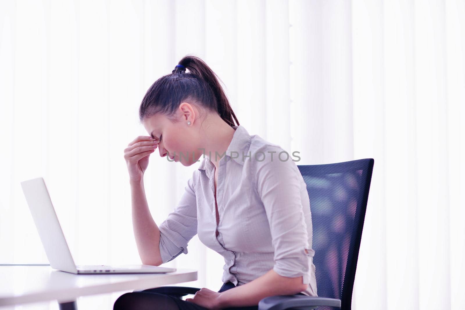 portrait of Young pretty business woman work on  notebook computer  in the bright modern office indoors