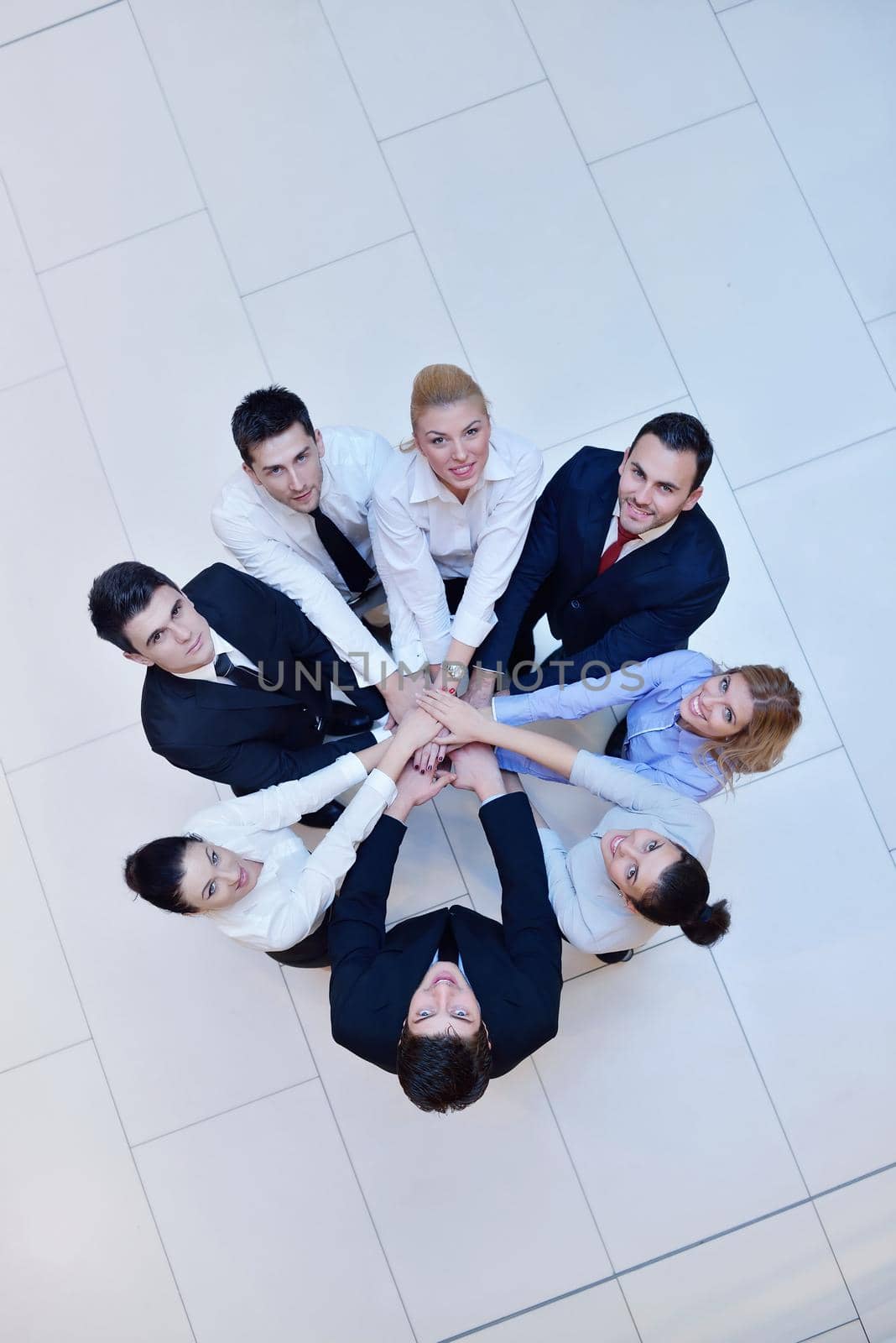 business people group joining hands and stay as team in circle  and representing concept of friendship and teamwork