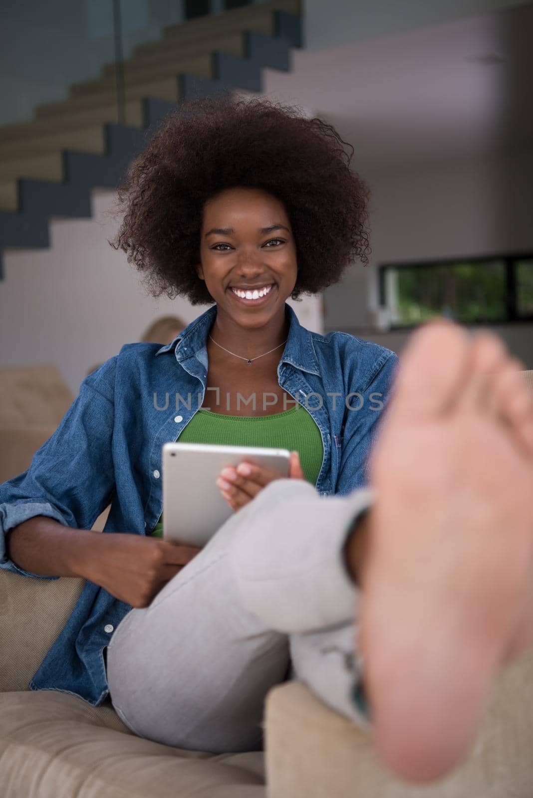 african american woman at home with digital tablet by dotshock