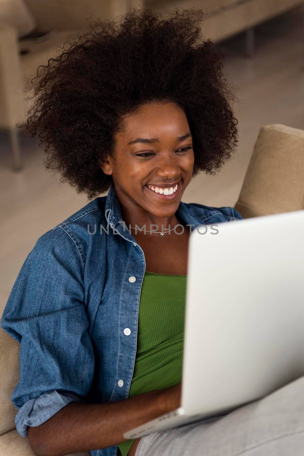 African American women at home in the chair using a laptop by dotshock