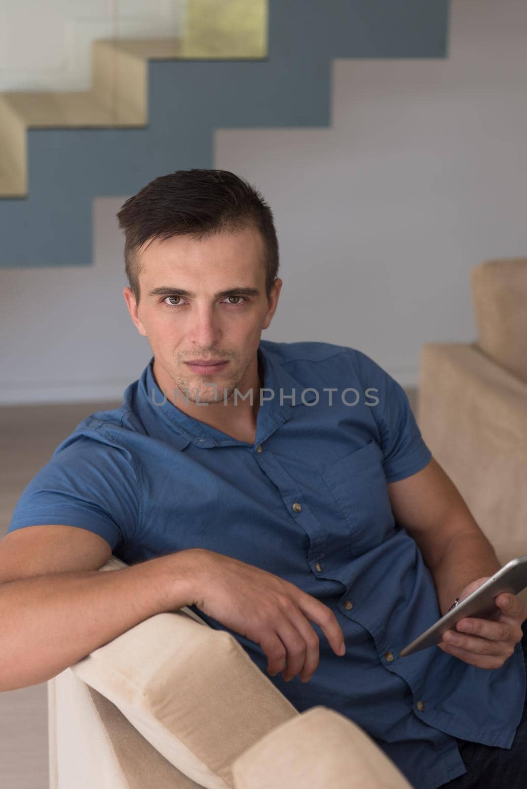 Handsome casual young man using a tablet at luxurious home