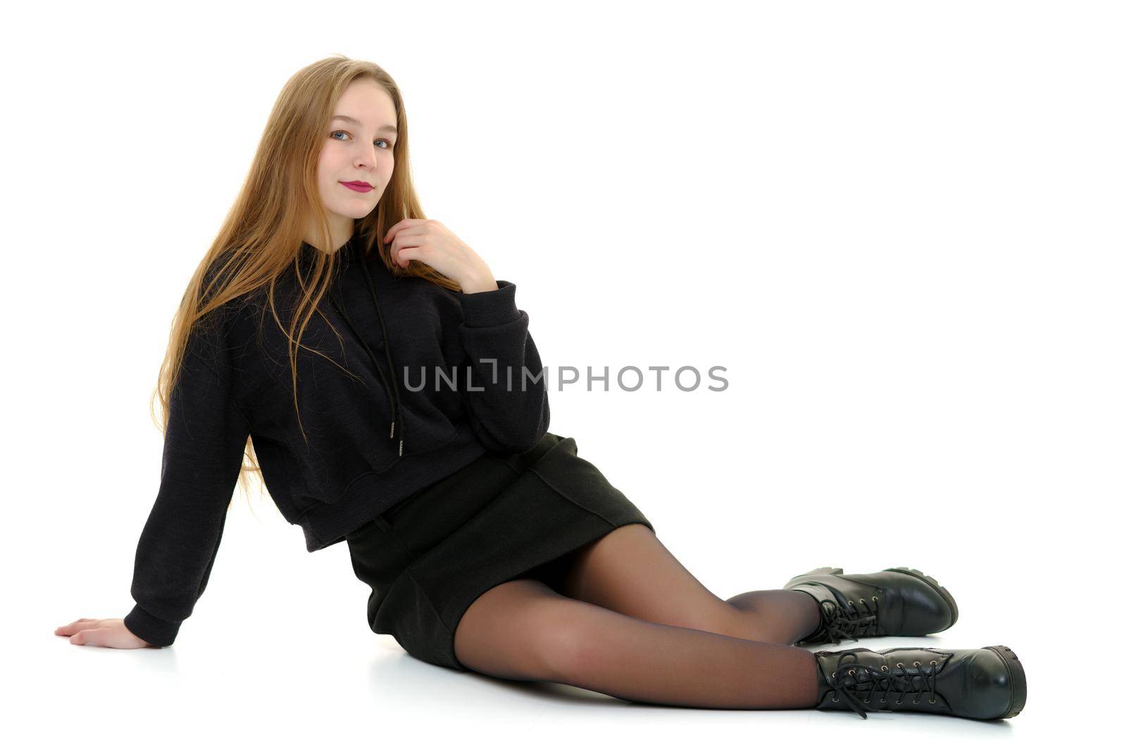A teenage girl is sitting on the floor. by kolesnikov_studio