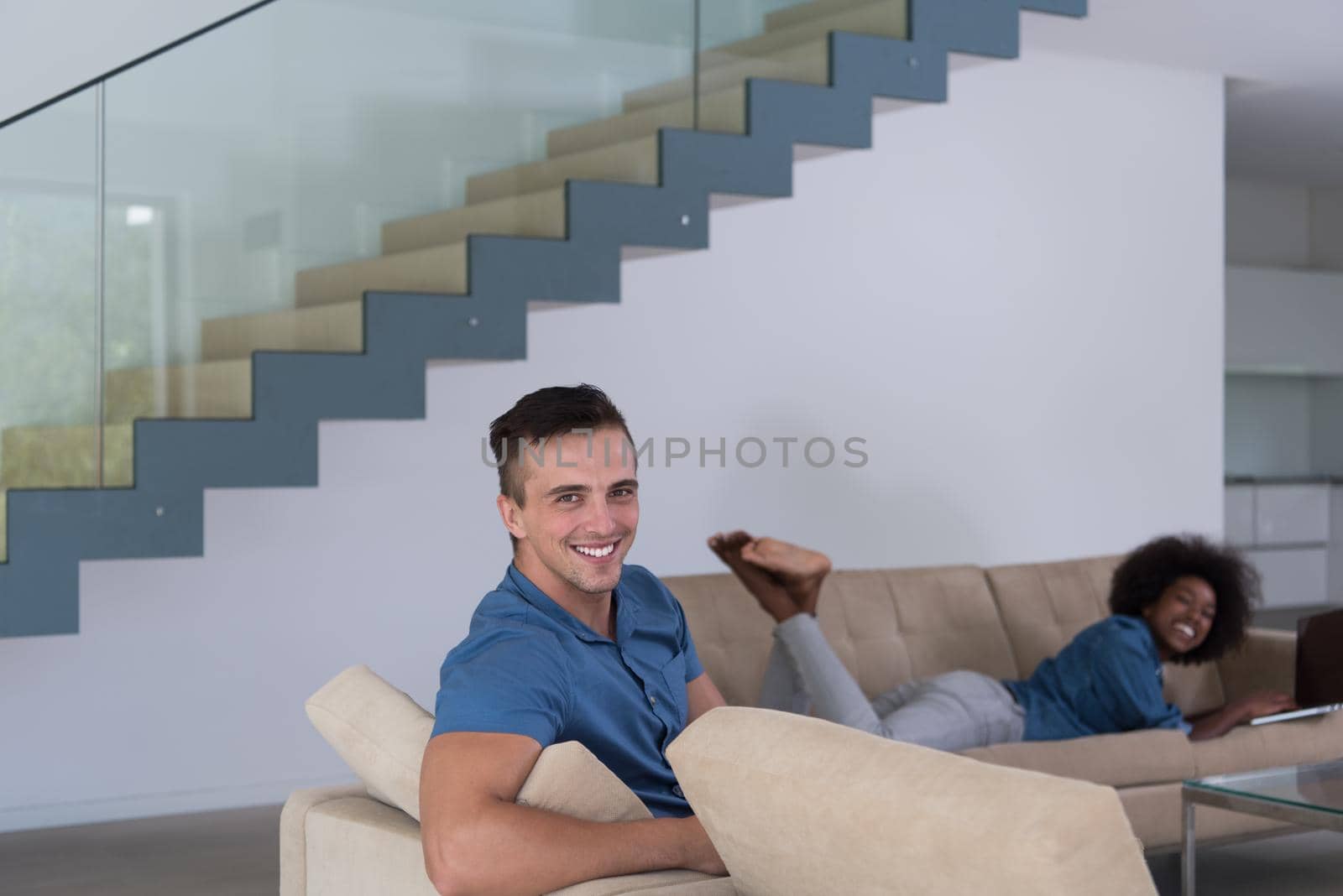 young multiethnic couple relaxes in the living room by dotshock