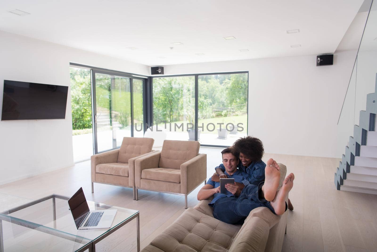 young multiethnic couple relaxes in the living room by dotshock