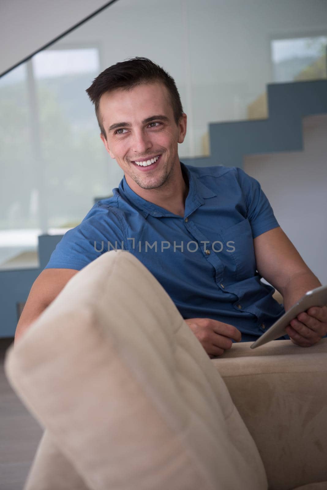 young man using a tablet at home by dotshock