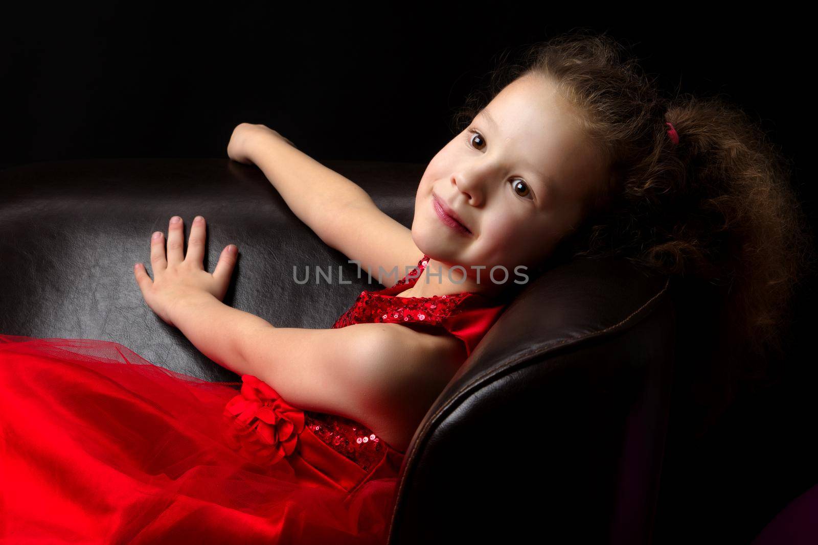 Beautiful little girl on a black background. Studio photography