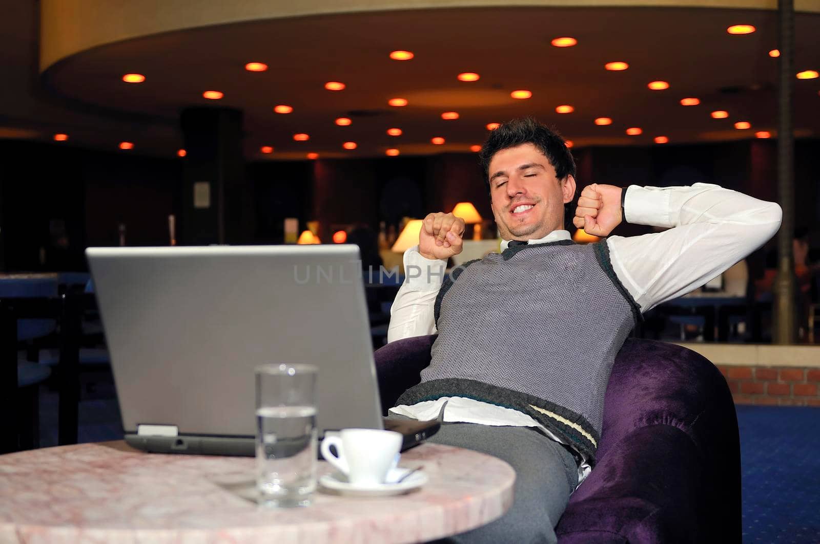 Happy young man sitting relaxed working on computer