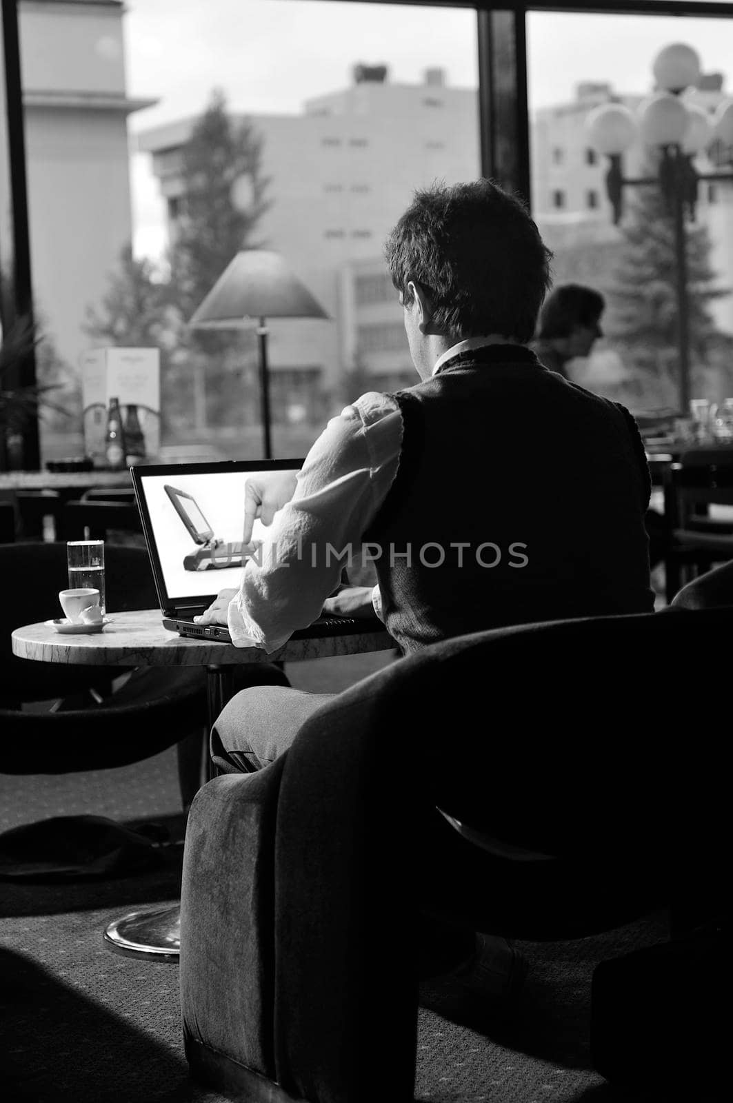 Happy man sitting and working on laptop by dotshock