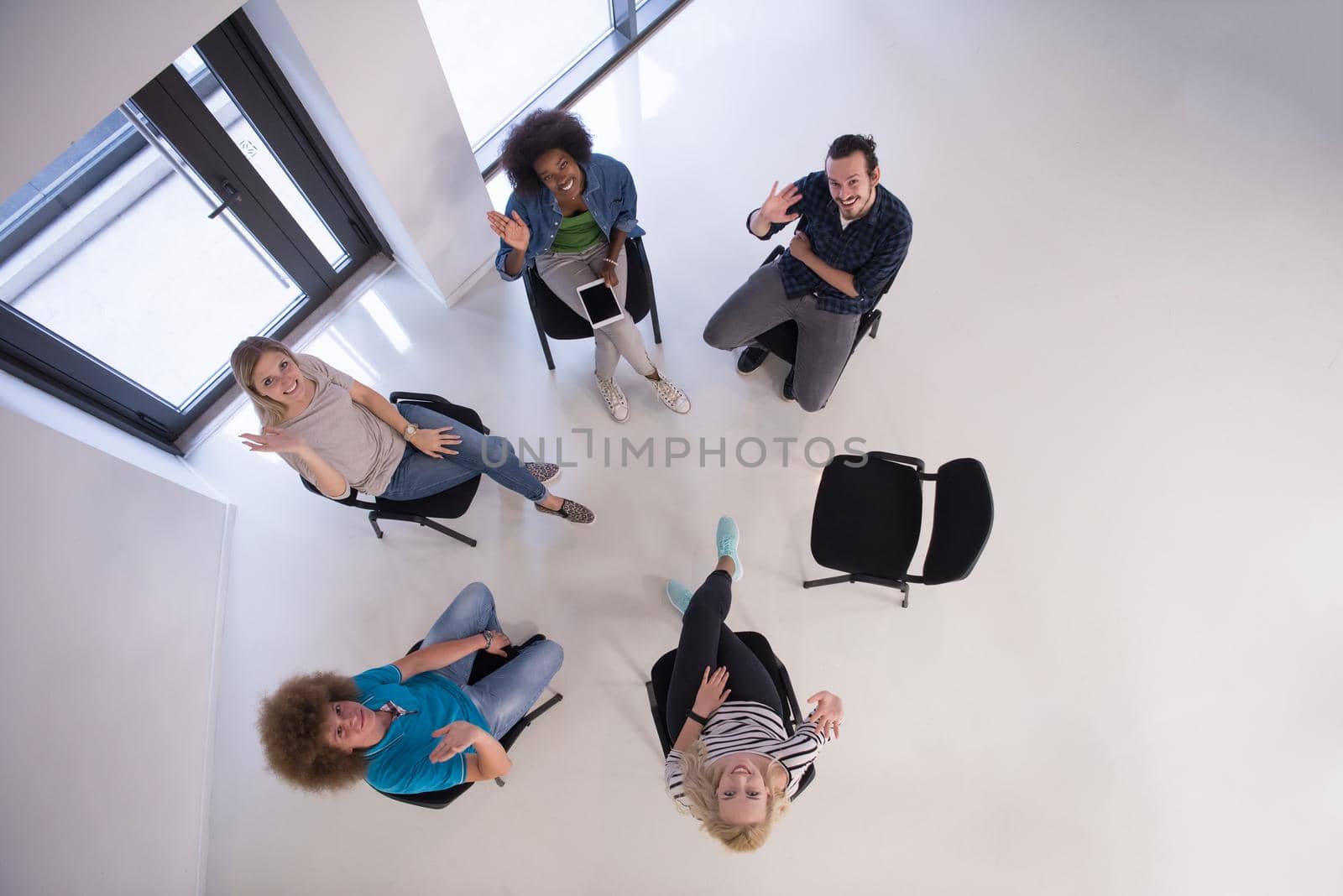 Multiethnic startup business team on meeting in modern bright office interior brainstorming, working on laptop and tablet computer top view