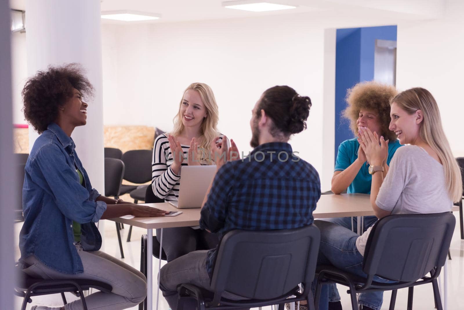 Multiethnic startup business team on meeting in modern bright office interior brainstorming, working on laptop and tablet computer