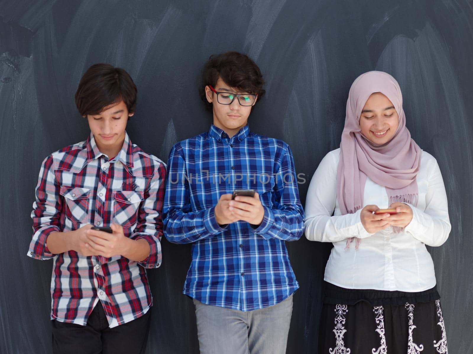arab teenagers group using smart phones for social media networking by dotshock