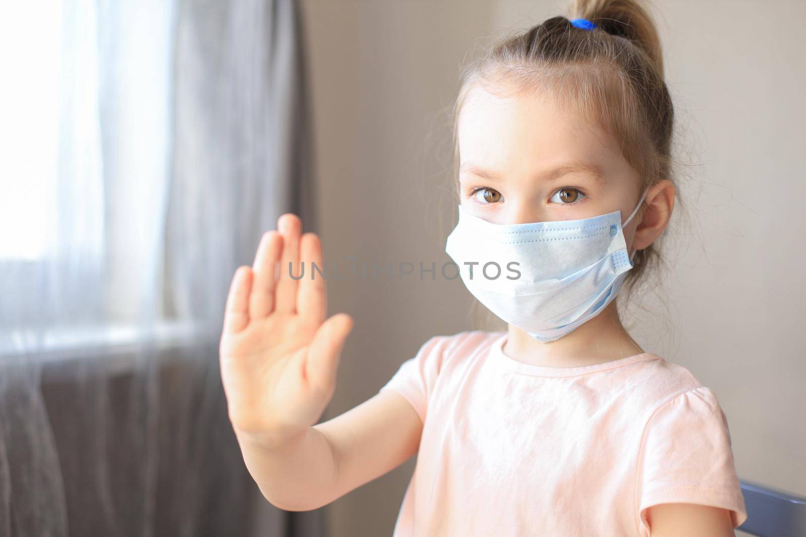 Little girl in medical masks showing Stop of COVID-19 epidemic