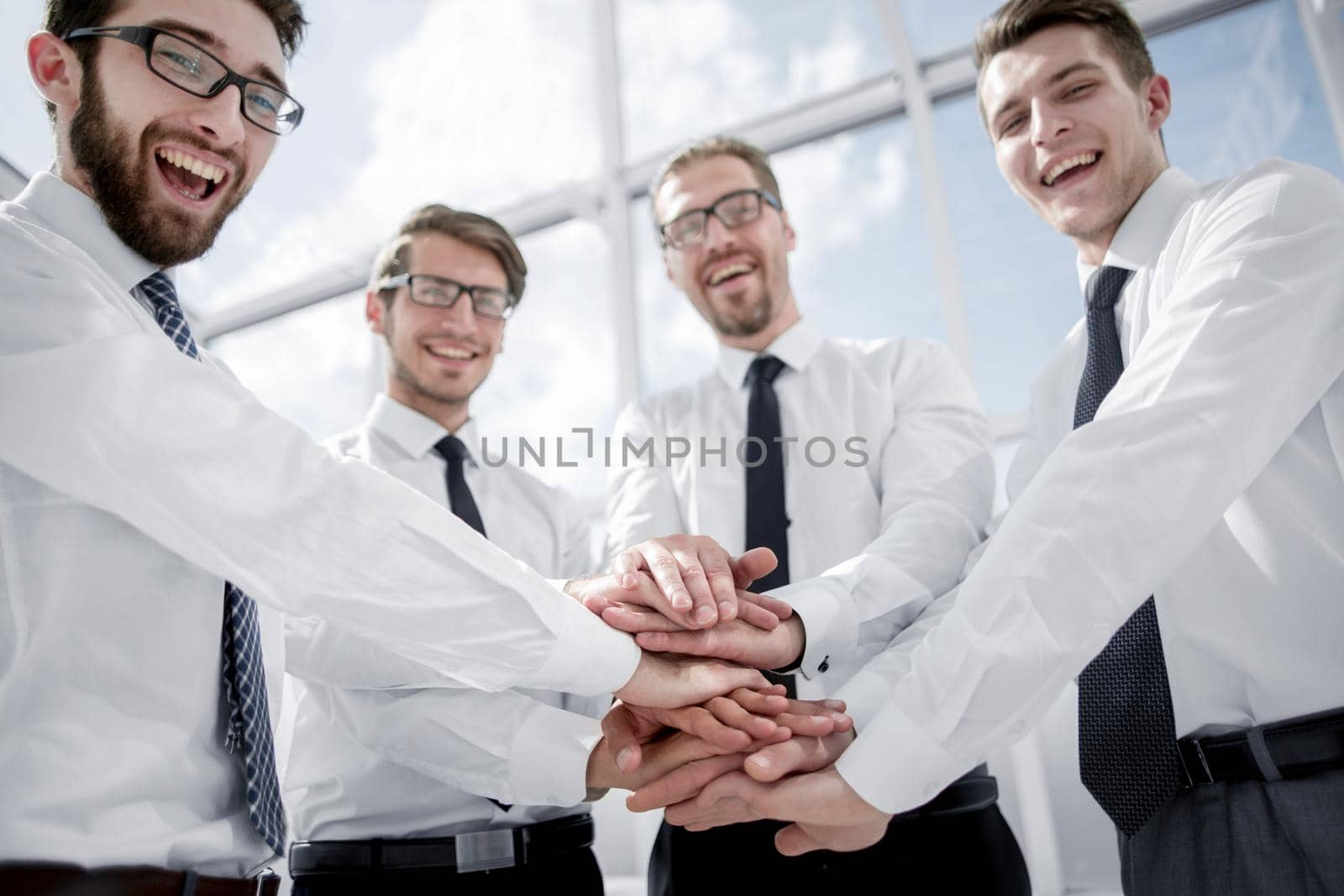 professional business team folding their hands together teamwork concept