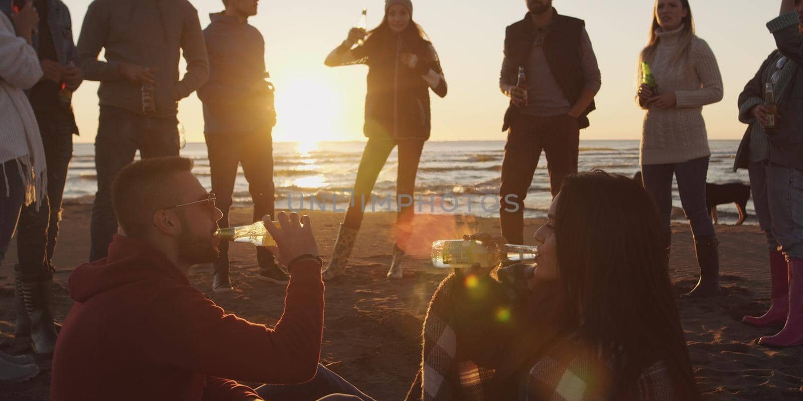 Friends having fun at beach on autumn day by dotshock