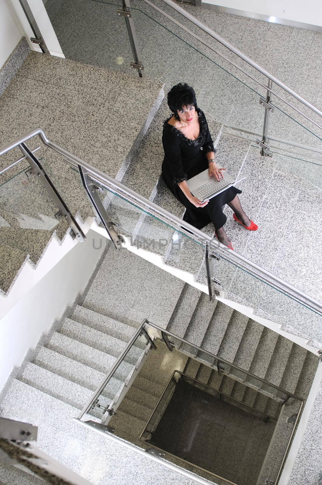 senior business woman work on laptop at modern staircase