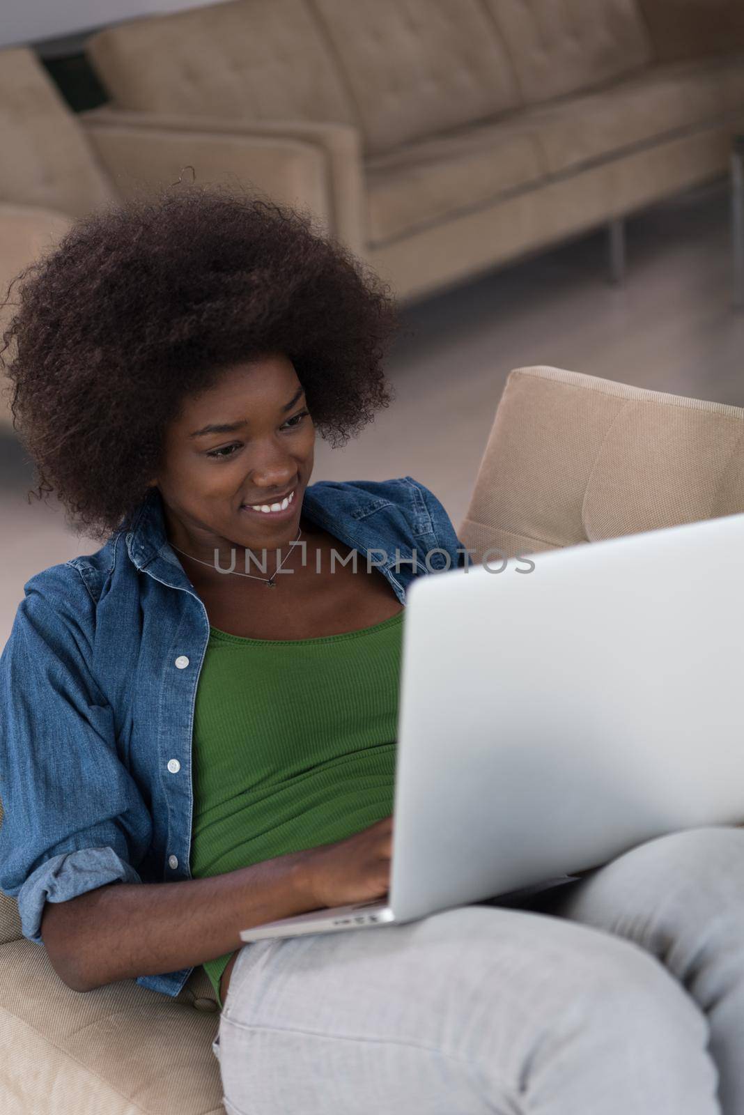 African American women at home in the chair using a laptop by dotshock