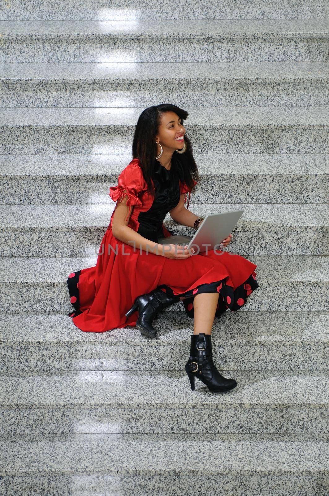 young business woman working wireless on laptop at indoor staircase