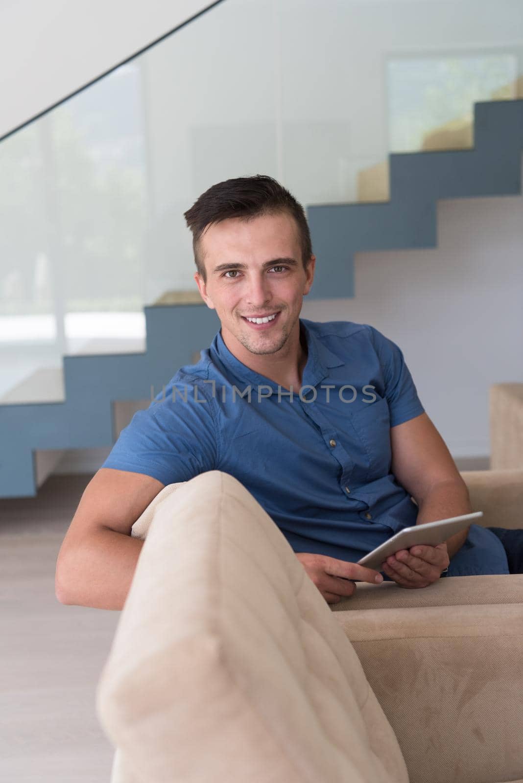 young man using a tablet at home by dotshock