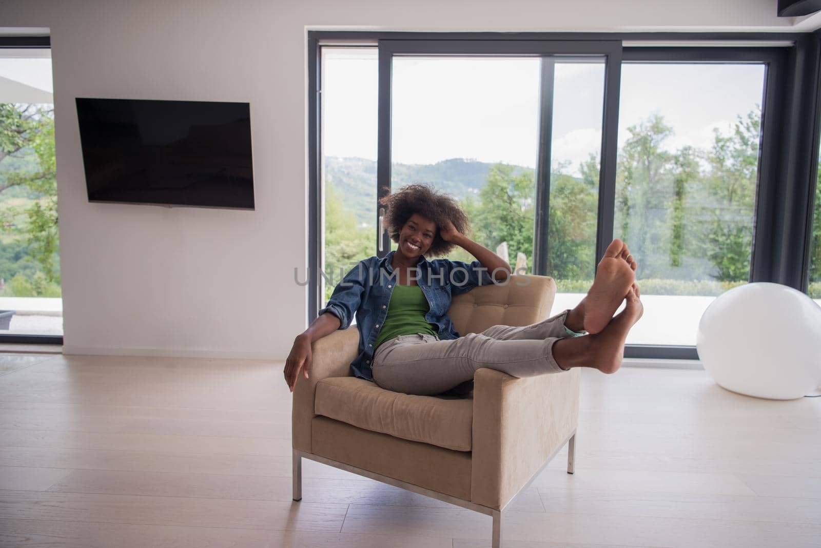 Young african american woman at home in the chair relaxing in her luxury home