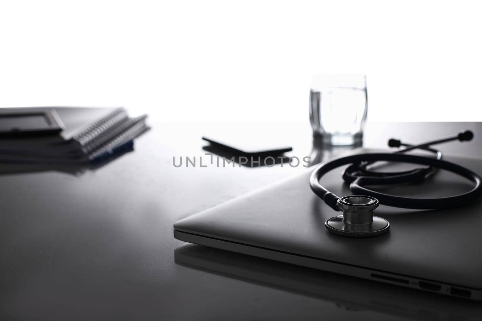 Medical stethoscope laptop and documents on desk by lenets