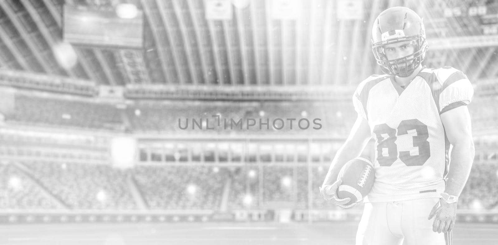 American Football Player isolated on big modern stadium field with lights and flares