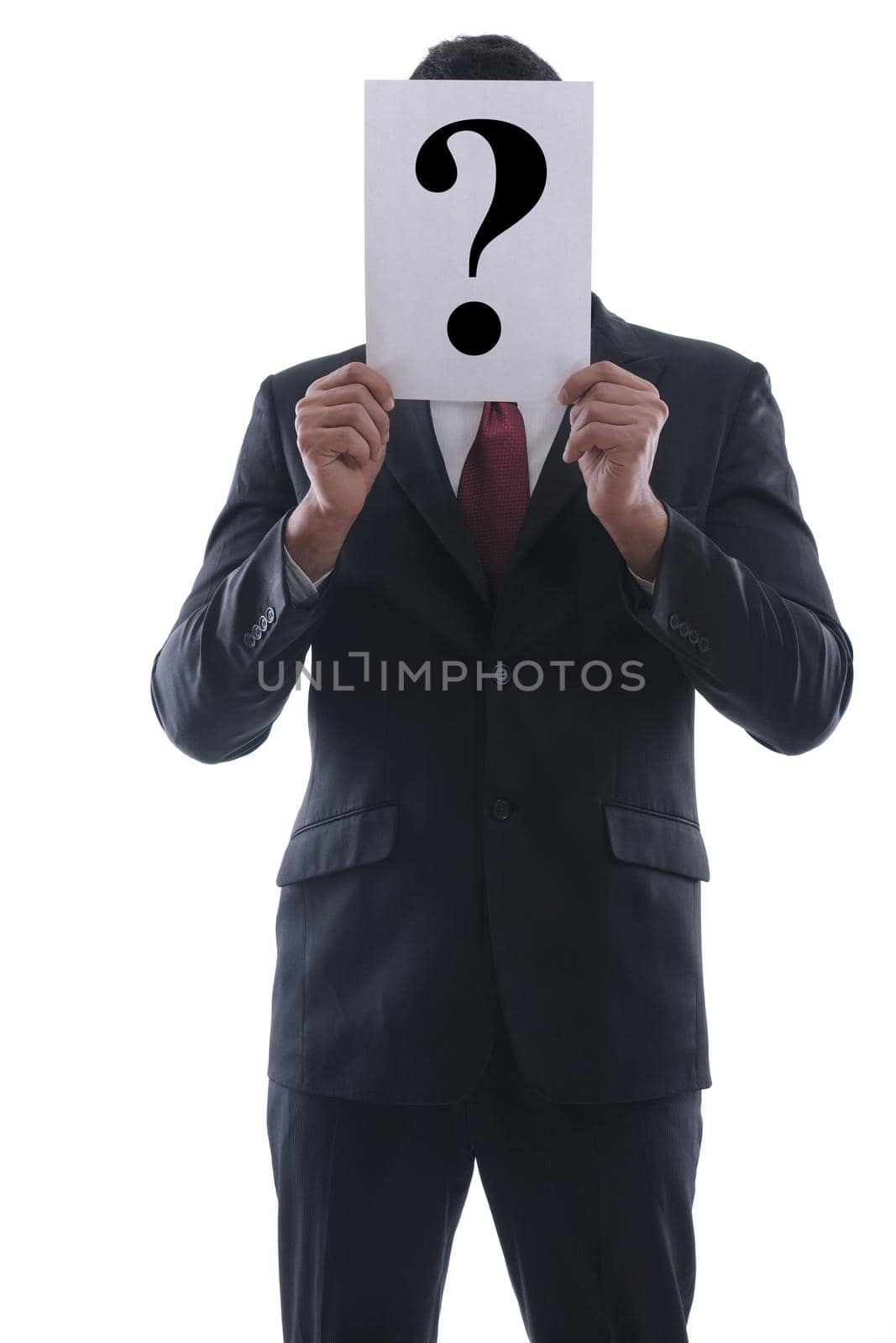 Business man holding a piece of paper over his face with a question mark on it isolated on white background in studio
