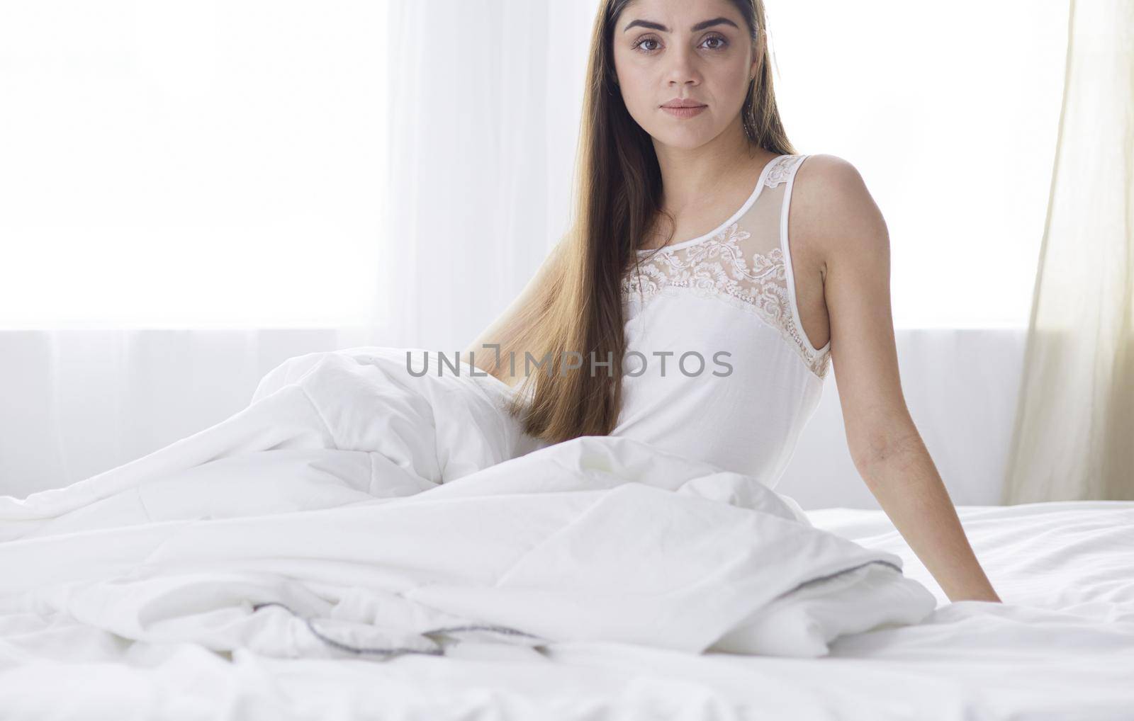 Pretty woman lying down on her bed at home.
