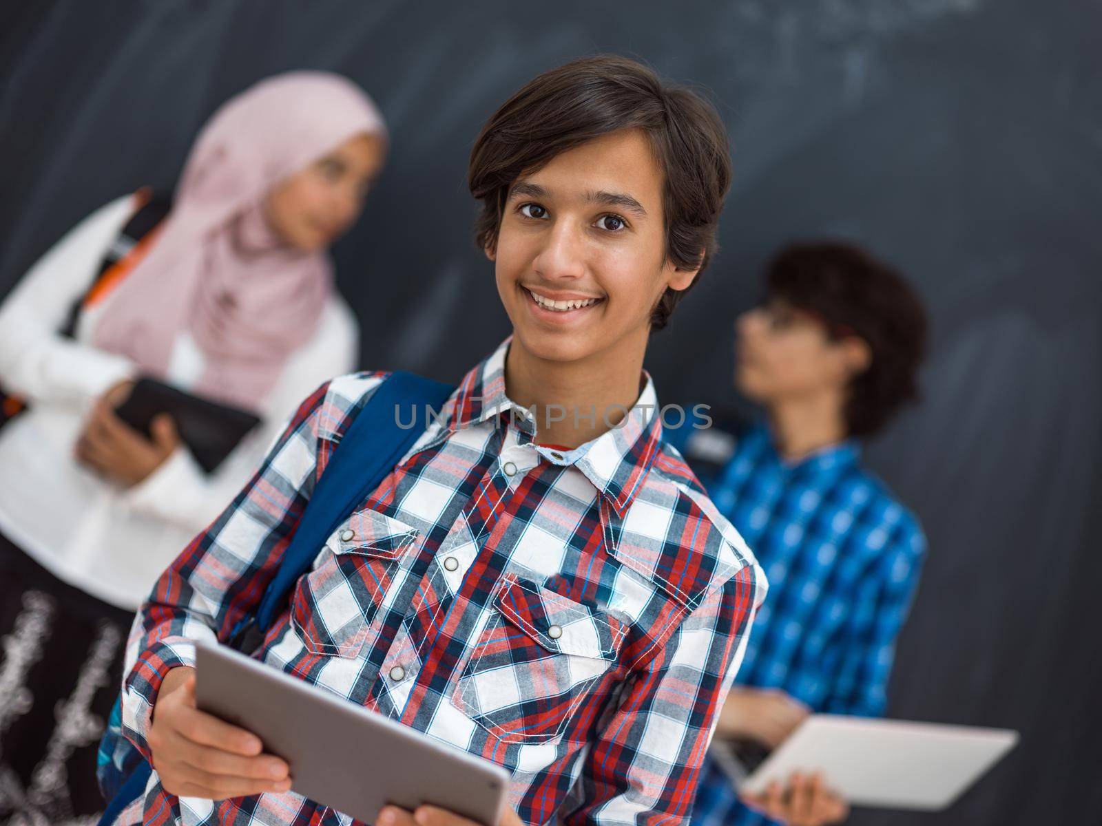 Modern Arab teens use smartphones, tablets, and laptops to study during online classes due to corona virus pandemic. High quality photo