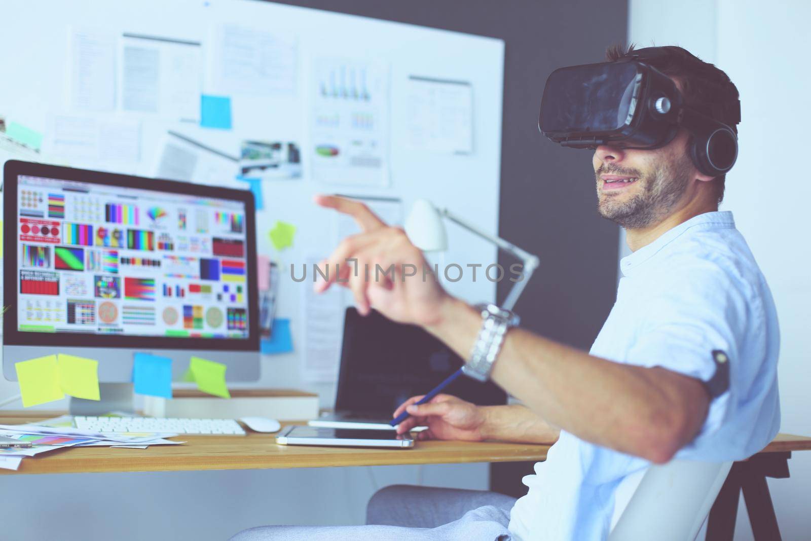 Young male software programmer testing a new app with 3d virtual reality glasses in office