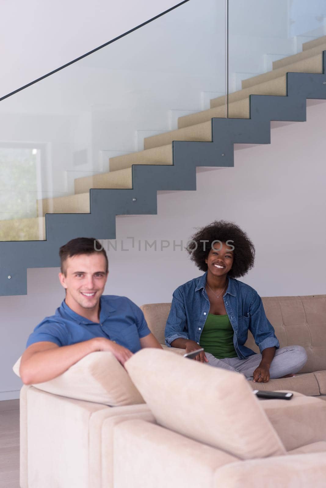 multiethnic couple relaxing at  home with tablet computers by dotshock