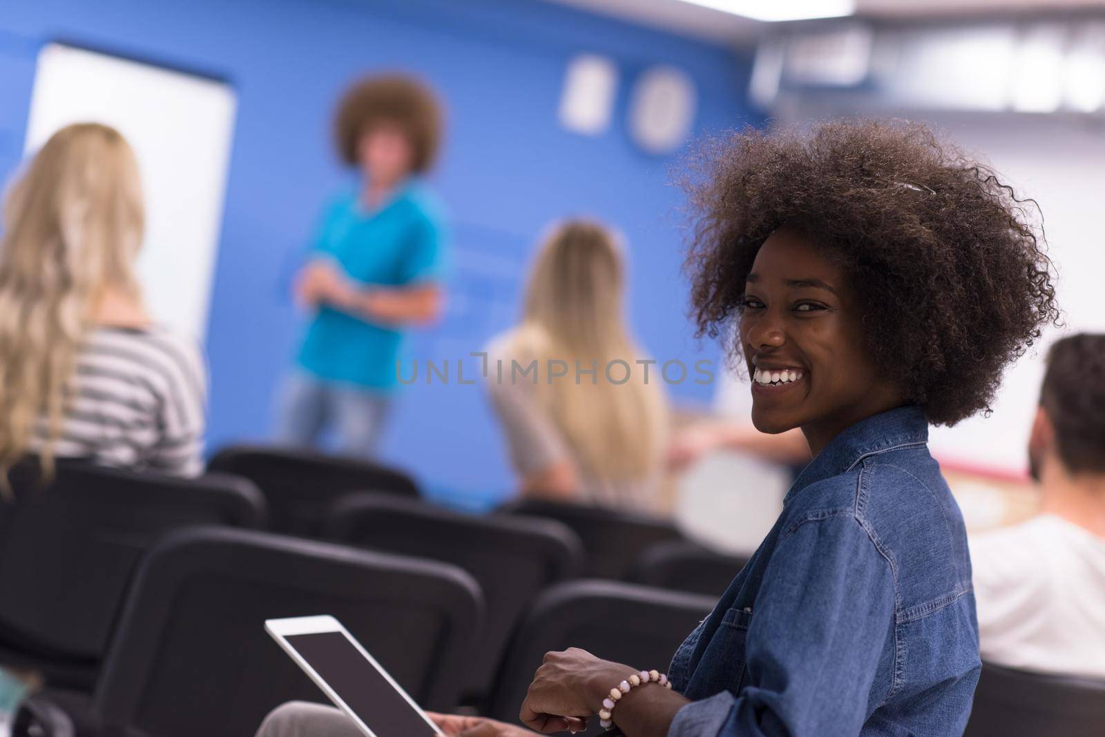 portrait of young African American business woman at modern startup office interior, team in meeting in background