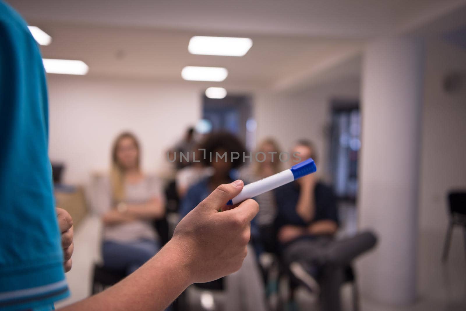 close up of teacher hand with marker while teaching lessons in school classroom to multiethnic students