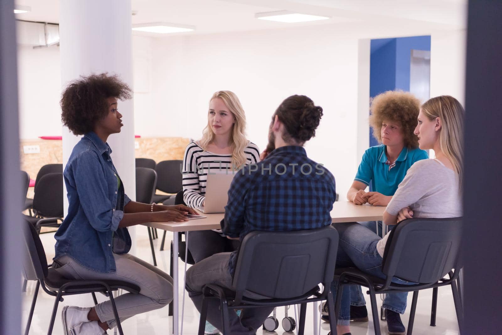 Multiethnic startup business team on meeting in modern bright office interior brainstorming, working on laptop and tablet computer