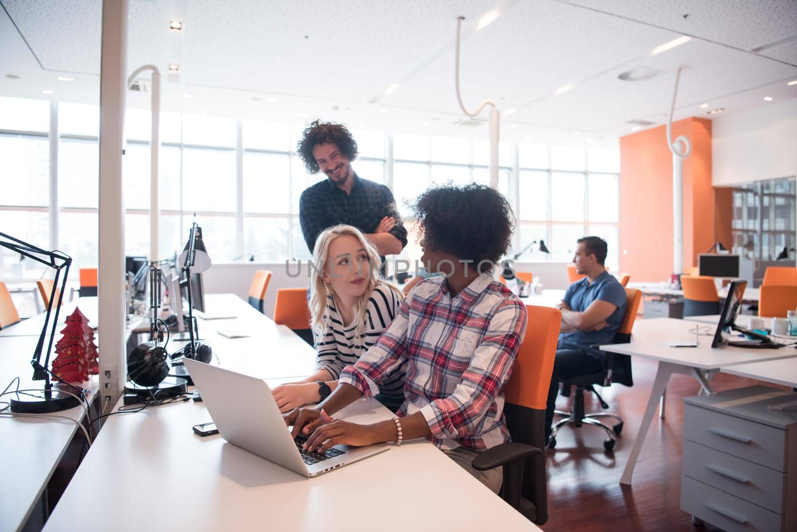 Multiethnic startup business team on meeting in modern bright office interior brainstorming, working on laptop