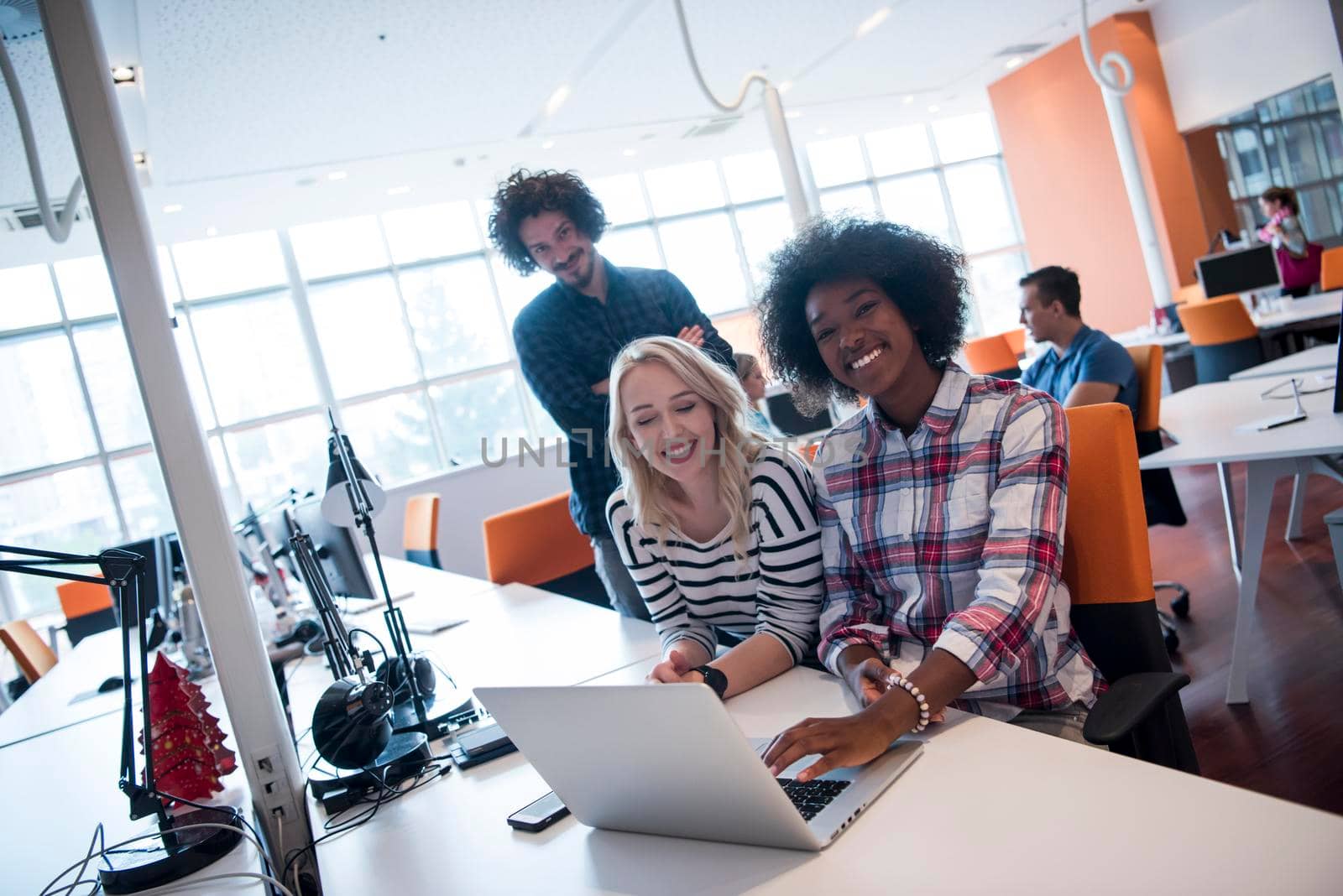 Multiethnic startup business team on meeting in modern bright office interior brainstorming, working on laptop