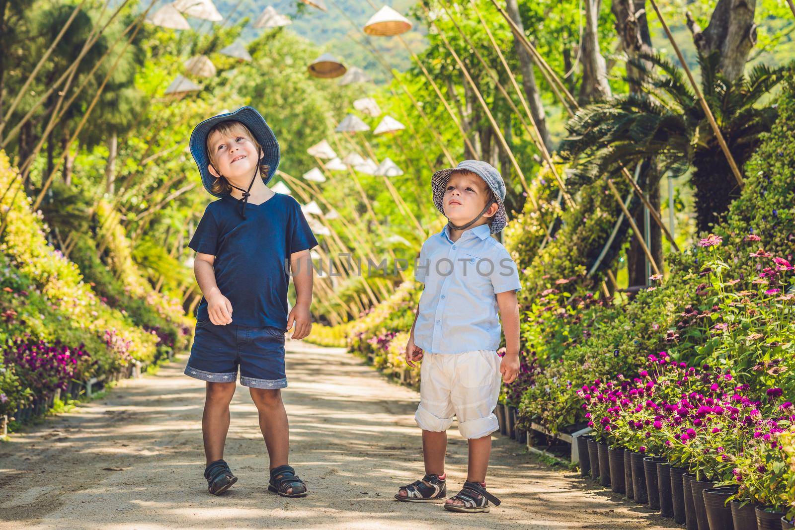 Two boys, a traveler in Vietnam, against the backdrop of Vietnamese hats. Traveling with children concept