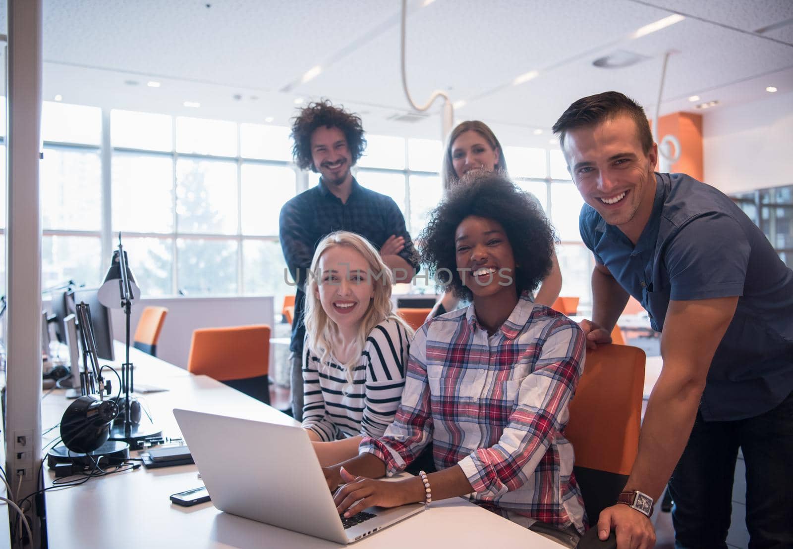 Multiethnic startup business team on meeting in modern bright office interior brainstorming, working on laptop