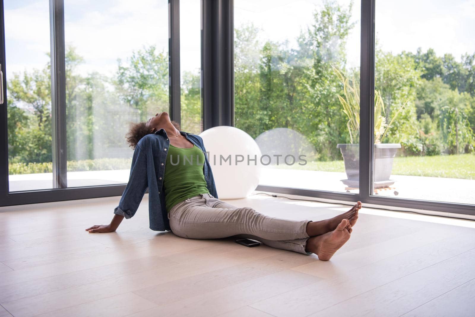 Beautiful african american young woman in casual fashion clothes sitting near window