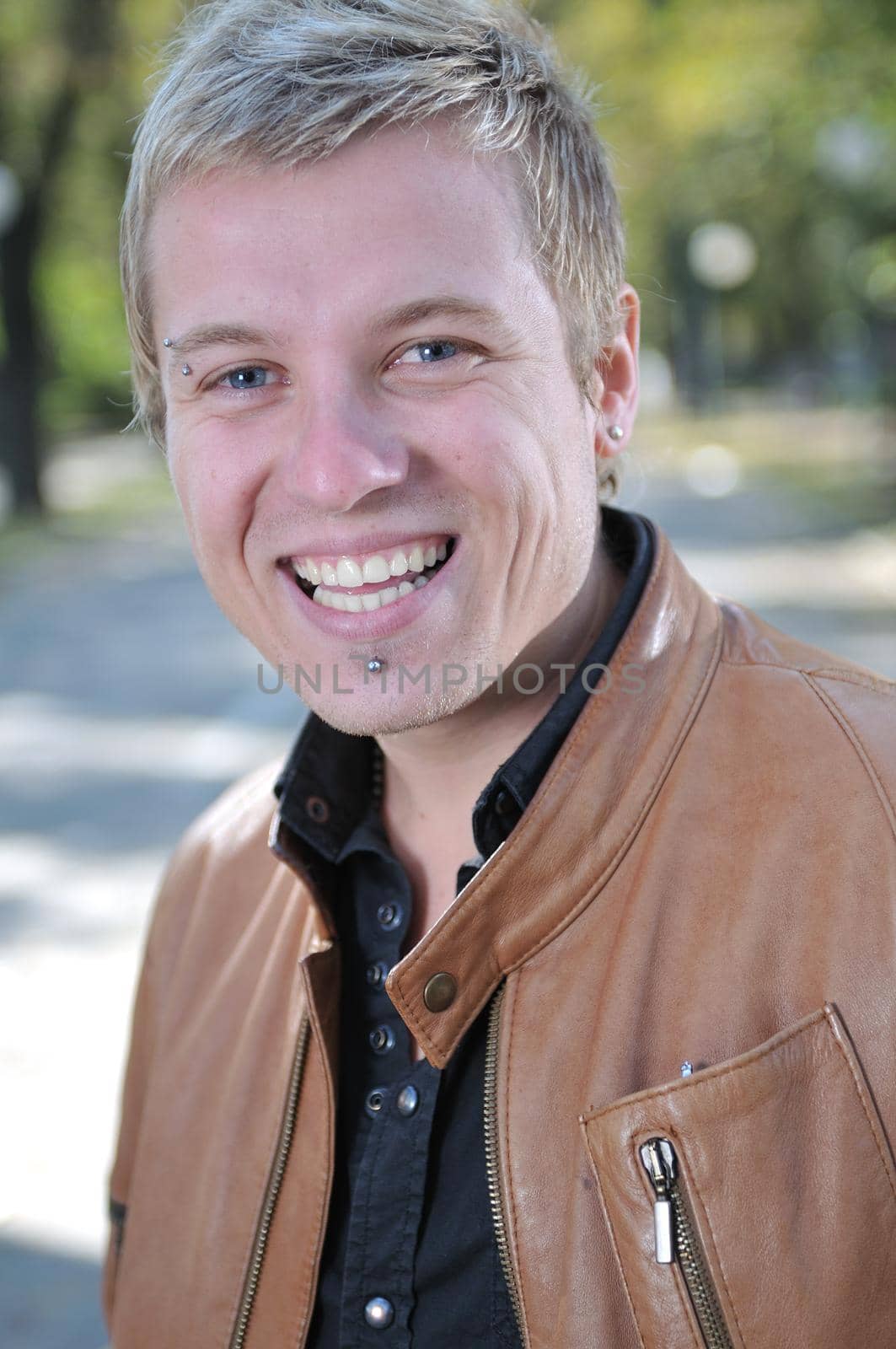 Handsome young man smiling outdoors by dotshock