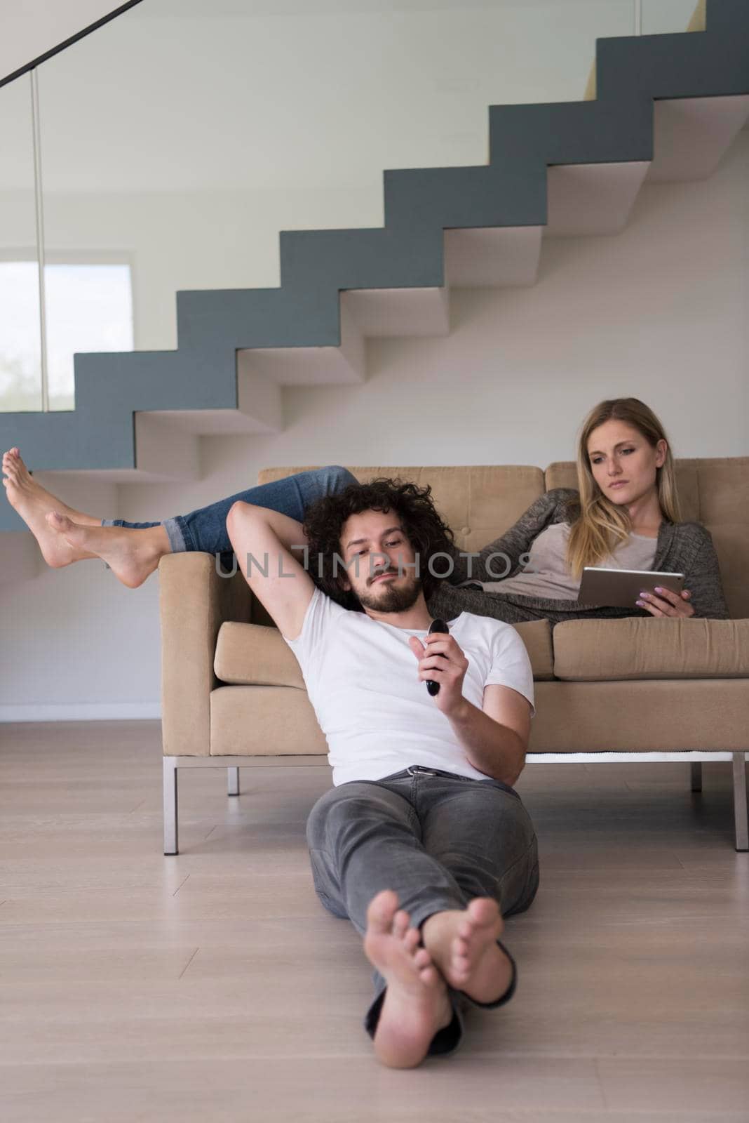 young couple relaxes in the living room by dotshock