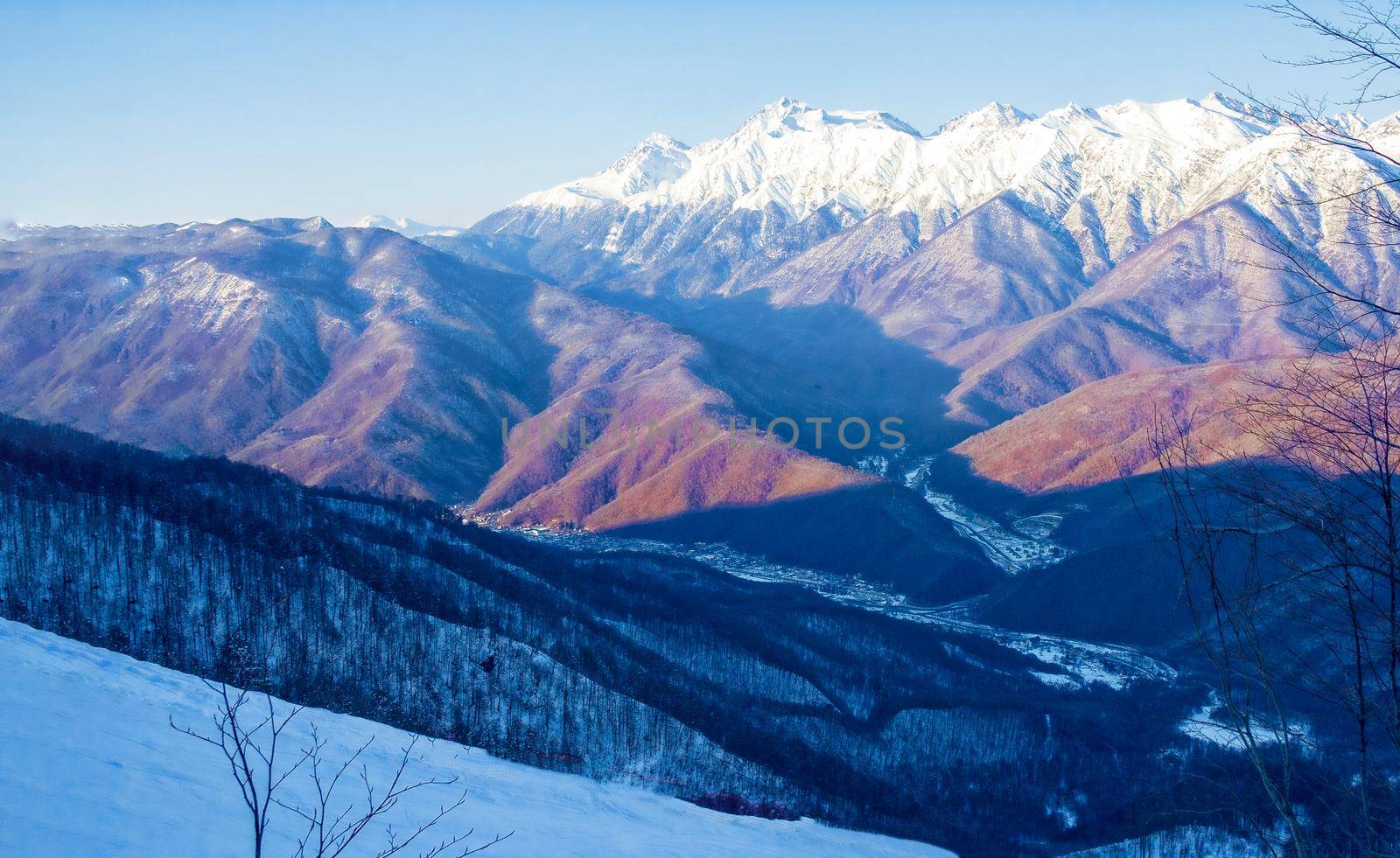 Magnificent view on a sunny frosty day, on the snow-covered mountain peaks lit by the morning sun. The concept of a family vacation, a photo on the advertising booklet. Sochi. Russia.