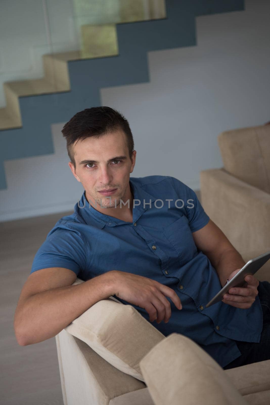 young man using a tablet at home by dotshock