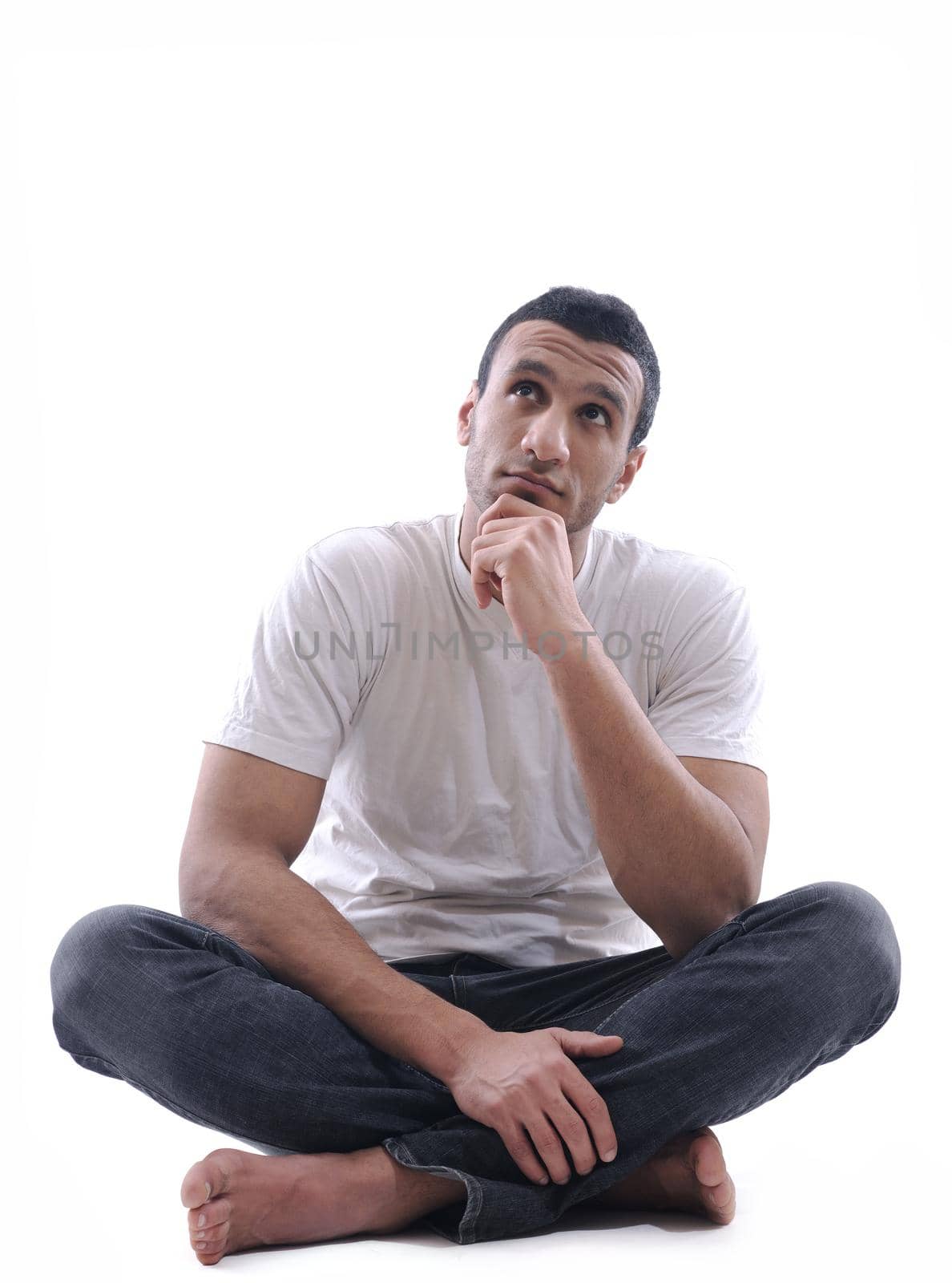 portrait of relaxed young man dressed in white shirt and jeans isolated over white background in studio