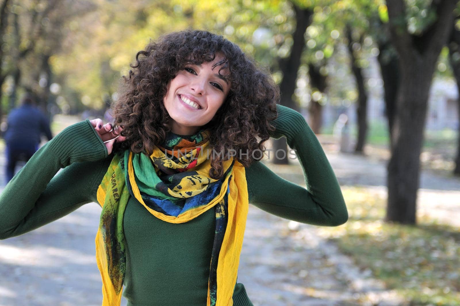 brunette Cute young woman with colorful scarf smiling outdoors in nature
