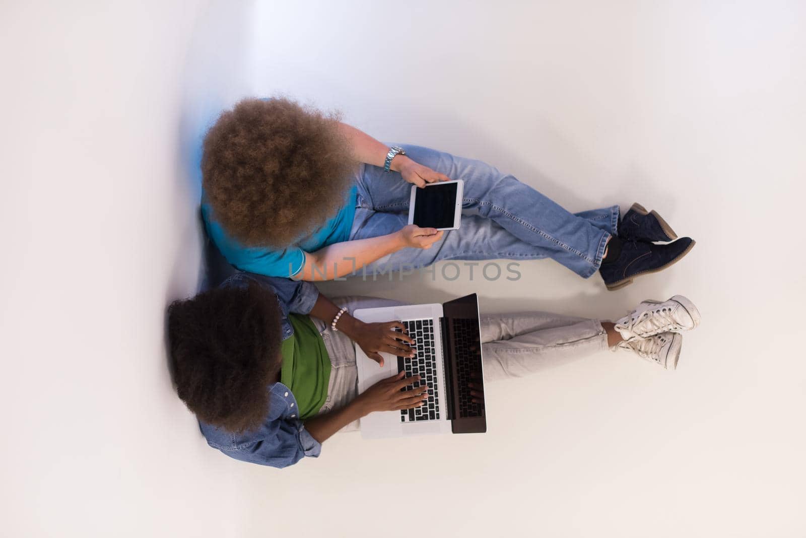 startup business and new mobile technology concept with young multiethnic couple in modern bright office interior working on laptop and tablet computer on new creative project and brainstorming top view