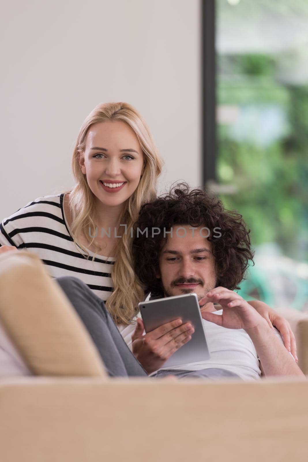 couple relaxing at  home with tablet computers by dotshock