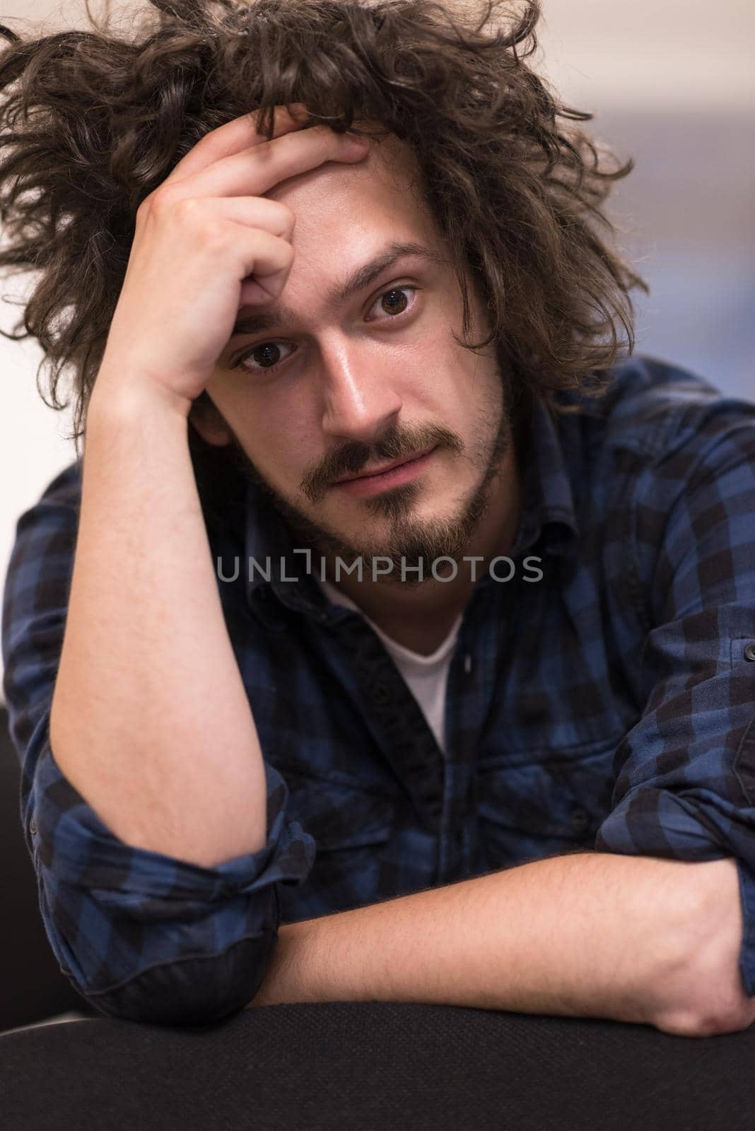 A student sits alone in a empty seats in a classroom