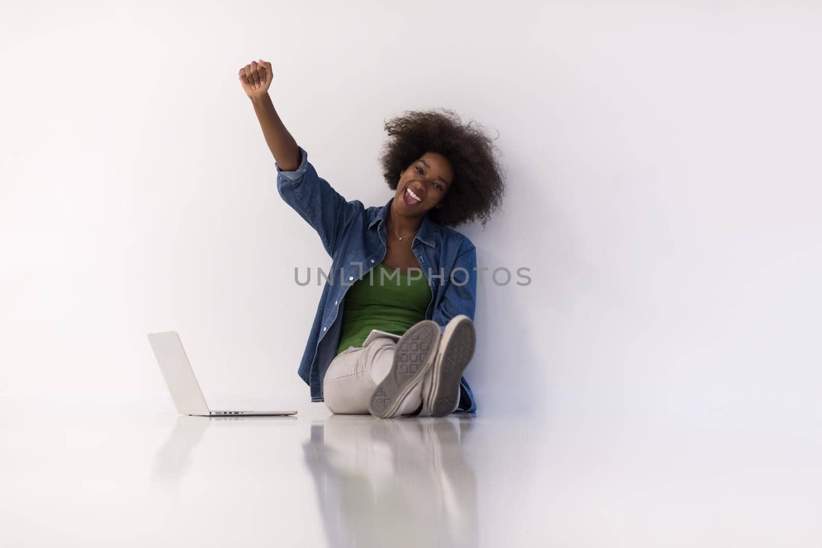 african american woman sitting on floor with laptop by dotshock